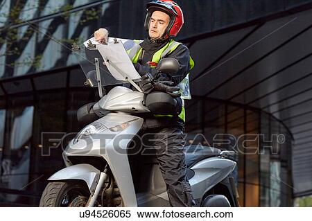 Stock Photography - Motor scooter rider with instructions for taxi driver training the knowledge. Fotosearch