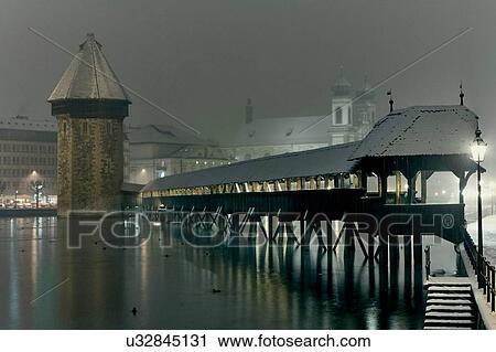Stock Image - Night time view of waterfront pier, Lucerne, Switzerland. Fotosearch