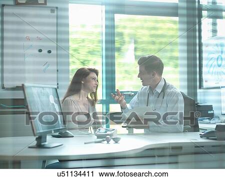 Stock Image - Orthopaedic consultant with patient in consulting room. Fotosearch