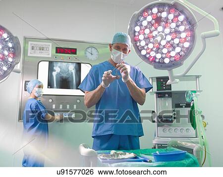 Orthopaedic surgeon and nurse in operating theatre View Large Photo Image Stock Photograph - Orthopaedic surgeon and nurse in operating theatre. Fotosearch