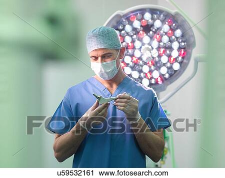 Orthopaedic surgeon in operating theatre with replacement hip stem View Large Photo Image Stock Image - Orthopaedic surgeon in operating theatre with replacement hip stem. Fotosearch