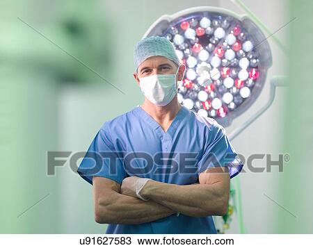 Stock Image - Orthopaedic surgeon in operating theatre, portrait. Fotosearch
