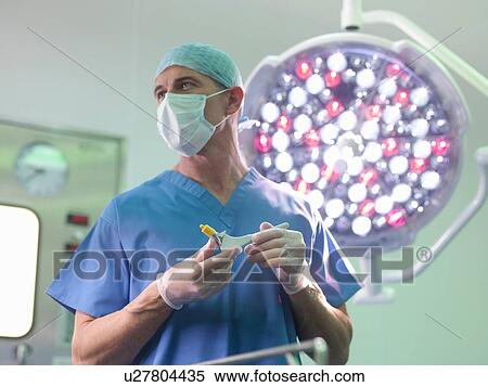Orthopaedic surgeon in operating theatre with replacement hip stem View Large Photo Image Stock Photography - Orthopaedic surgeon in operating theatre with replacement hip stem. Fotosearch