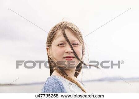 Stock Photo - Portrait of a girl with windswept hair, Thingvellir, Iceland. Fotosearch