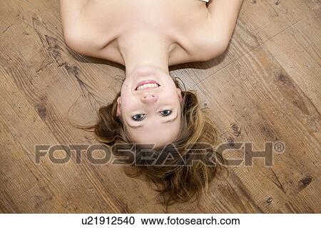 Portrait of bare shouldered young woman lying on wooden floorboards View Large Photo Image Stock Image - Portrait of bare shouldered young woman lying on wooden floorboards. Fotosearch