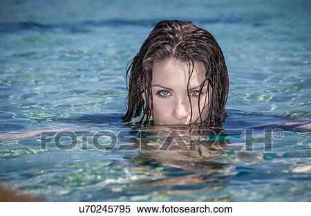 Stock Photography - Portrait of beautiful young woman with face submerged in sea. Fotosearch