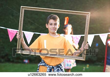 Portrait of boy looking through picture frame, looking at camera View Large Photo Image Stock Photography - Portrait of boy looking through picture frame, looking at camera. Fotosearch