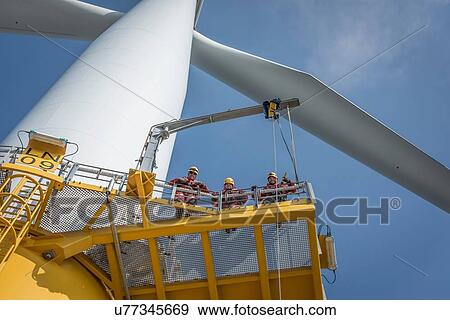 Stock Photo - Portrait of engineers on wind turbine at offshore windfarm. Fotosearch