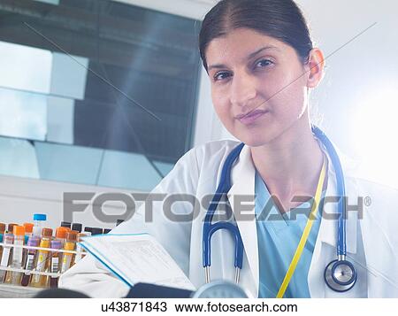 Portrait of female doctor reading medical notes in hospital View Large Photo Image Stock Image - Portrait of female doctor reading medical notes in hospital. Fotosearch