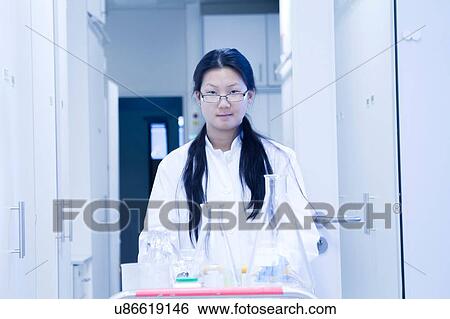 Portrait of female scientist pushing trolley in laboratory View Large Photo Image Stock Photograph - Portrait of female scientist pushing trolley in laboratory. Fotosearch