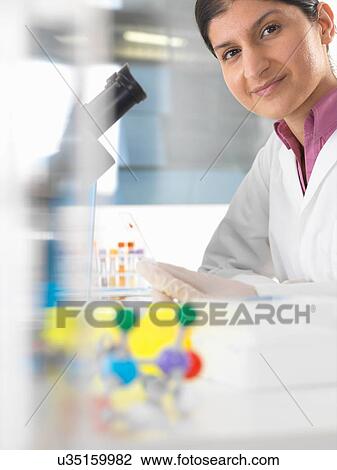 Portrait of female scientist testing blood sample using microscope View Large Photo Image Stock Image - Portrait of female scientist testing blood sample using microscope. Fotosearch