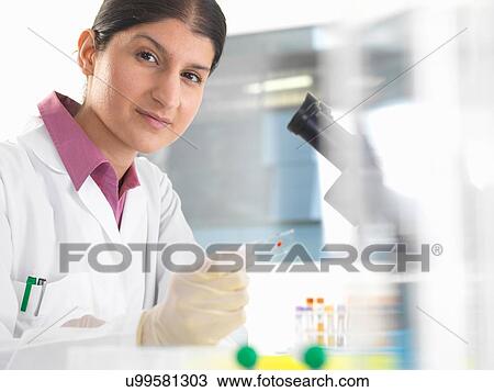 Portrait of female scientist testing blood samples using microscope View Large Photo Image Stock Image - Portrait of female scientist testing blood samples using microscope. Fotosearch