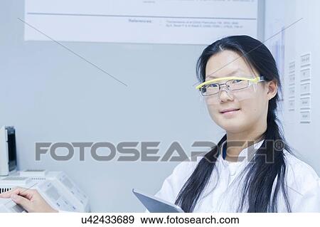 Stock Photo - Portrait of female scientist with digital tablet in laboratory. Fotosearch