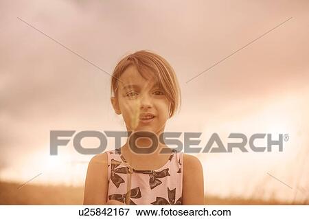 Portrait of girl with ear of wheat in front of her face in wheat field View Large Photo Image Stock Photo - Portrait of girl with ear of wheat in front of her face in wheat field. Fotosearch