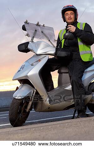 Portrait of motor scooter rider taking a break on city roadside View Large Photo Image Stock Image - Portrait of motor scooter rider taking a break on city roadside. Fotosearch