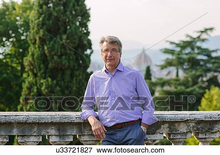 Stock Photo - Portrait of senior man, leaning against wall. Fotosearch