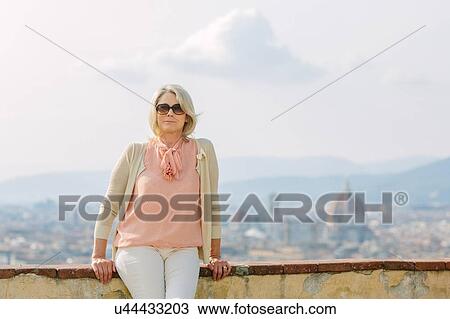 Portrait of senior woman, sitting on wall View Large Photo Image Stock Image - Portrait of senior woman, sitting on wall. Fotosearch
