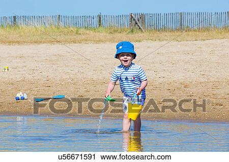 Portrait of small boy collecting seawater in toy bucket at beach, Marennes, Charente-Maritime, France View Large Photo Image Stock Image - Portrait of small boy collecting seawater in toy bucket at beach, Marennes, Charente-Maritime, France. Fotosearch
