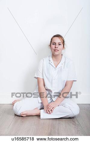 Portrait of young nurse sitting on floor View Large Photo Image Stock Photo - Portrait of young nurse sitting on floor. Fotosearch