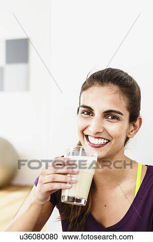 Portrait of young woman taking an exercise break drinking juice View Large Photo Image Stock Image - Portrait of young woman taking an exercise break drinking juice. Fotosearch