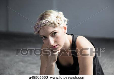 Stock Image - Portrait of young woman with braided hair. Fotosearch