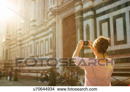 Rear view of mid adult woman using smartphone to take photograph, Duomo Cathedral, Florence, Italy View Large Photo Image Picture - Rear view of mid adult woman using smartphone to take photograph, Duomo Cathedral, Florence, Italy. Fotosearch