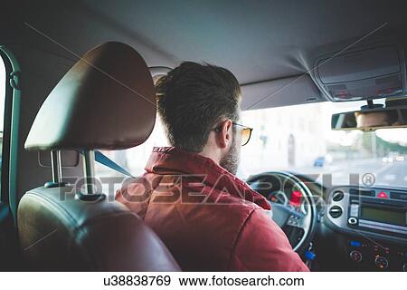 Rear view of young man on the road driving car View Large Photo Image Stock Photo - Rear view of young man on the road driving car. Fotosearch
