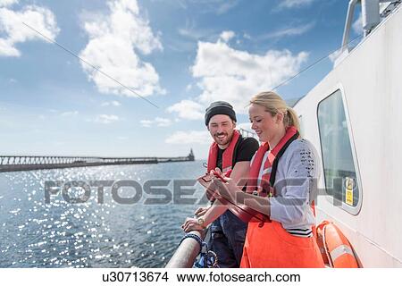 Picture - Research scientists looking at wildlife on research ship. Fotosearch