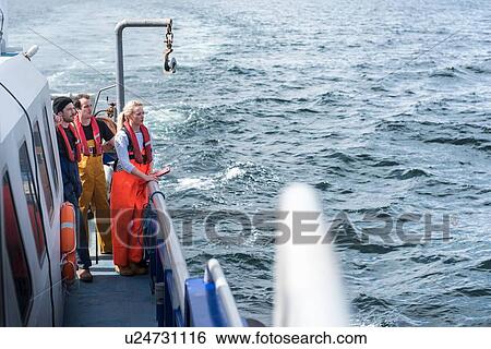 Scientists on deck of research ship looking out to sea View Large Photo Image Stock Photograph - Scientists on deck of research ship looking out to sea. Fotosearch