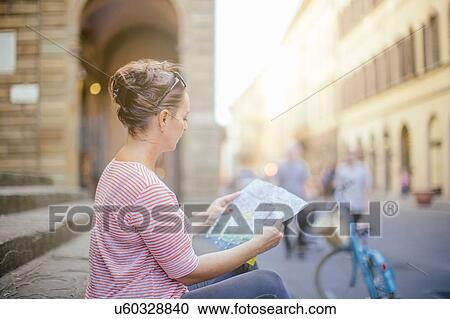 Side view of mid adult woman sitting looking at map View Large Photo Image Stock Image - Side view of mid adult woman sitting looking at map. Fotosearch