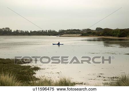 Silhouetted male canoeist on rural lake View Large Photo Image Stock Photography - Silhouetted male canoeist on rural lake. Fotosearch