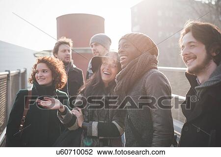 Six young adult friends chatting and laughing on footbridge View Large Photo Image Stock Image - Six young adult friends chatting and laughing on footbridge. Fotosearch