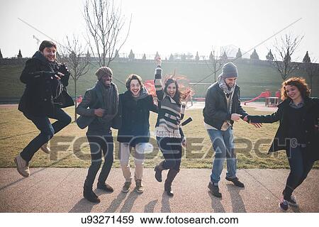 Stock Photo - Six young adult friends dancing and jumping in park. Fotosearch
