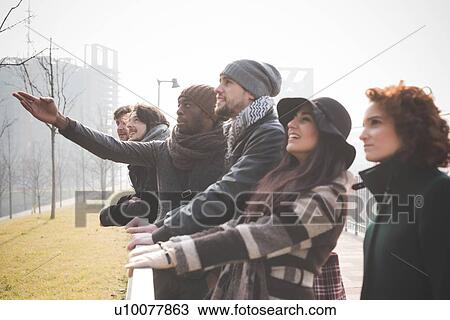 Stock Image - Six young adult friends looking at nature in park. Fotosearch