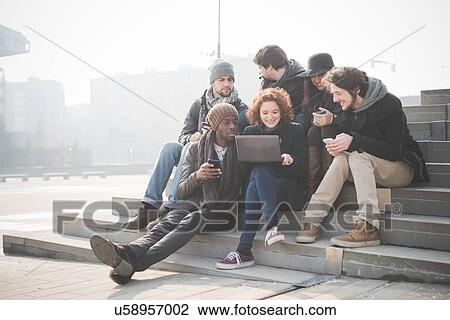 Six young adult friends on steps browsing laptop View Large Photo Image Stock Image - Six young adult friends on steps browsing laptop. Fotosearch