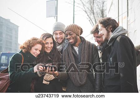 Six young adult friends reading smartphone texts View Large Photo Image Stock Photo - Six young adult friends reading smartphone texts. Fotosearch