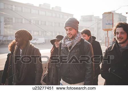 Stock Image - Six young adult friends strolling on city street. Fotosearch