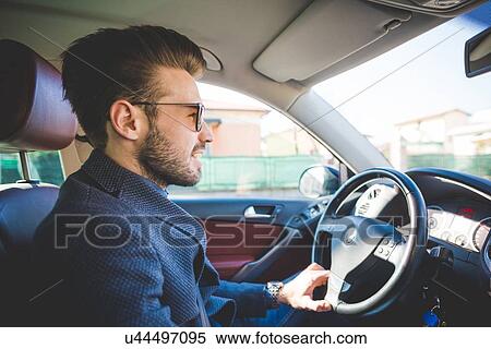Stock Photography - Stylish young man driving car. Fotosearch