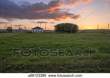 Sunset view of field with distant rural house View Large Photo Image Stock Photo - Sunset view of field with distant rural house. Fotosearch