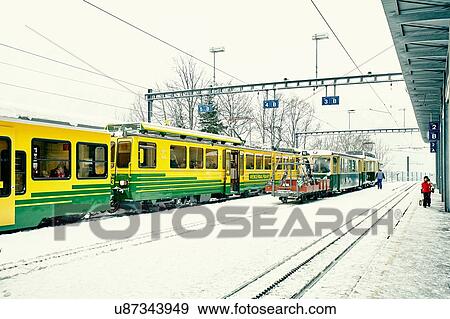 Trains and passengers in snow covered train station, Wengen, Switzerland View Large Photo Image Stock Photo - Trains and passengers in snow covered train station, Wengen, Switzerland. Fotosearch