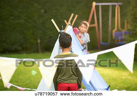 Two brothers preparing homemade tent in garden View Large Photo Image Stock Photo - Two brothers preparing homemade tent in garden. Fotosearch