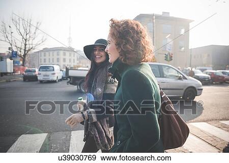 Stock Photo - Two female friends on pedestrian crossing. Fotosearch