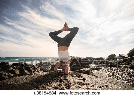 Woman practising yoga by ocean, Cape Town, South Africa View Large Photo Image Picture - Woman practising yoga by ocean, Cape Town, South Africa. Fotosearch