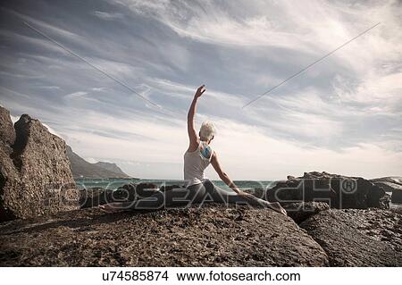 Woman practising yoga by ocean, Cape Town, South Africa View Large Photo Image Picture - Woman practising yoga by ocean, Cape Town, South Africa. Fotosearch