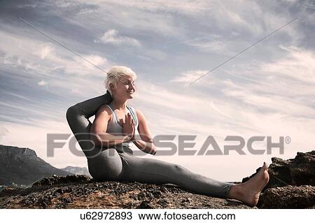 Stock Image - Woman practising yoga by ocean, Cape Town, South Africa. Fotosearch