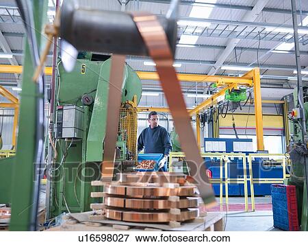 Worker operating copper punching machine in engineering factory View Large Photo Image Stock Photo - Worker operating copper punching machine in engineering factory. Fotosearch