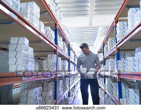 Stock Image - Worker picking orthopaedic medical products from store. Fotosearch