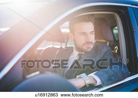 Young businessman looking out from car window View Large Photo Image Stock Image - Young businessman looking out from car window. Fotosearch