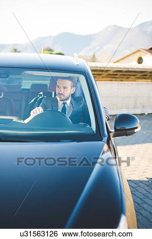 Young businessman sitting in car View Large Photo Image Stock Photograph - Young businessman sitting in car. Fotosearch