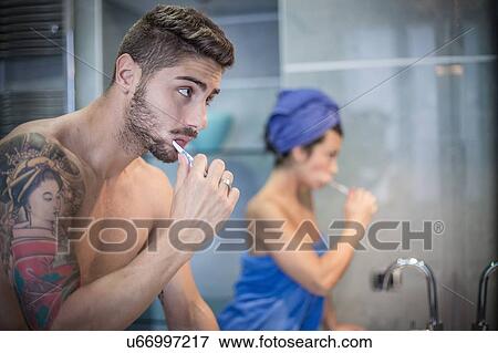 Young couple brushing teeth in bathroom View Large Photo Image Stock Photo - Young couple brushing teeth in bathroom. Fotosearch